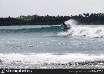 Serfer on the wave on the Pantai Sorake beach in Nias island, Indonesia