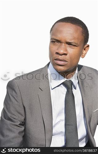 Serious African American businessman looking away over white background