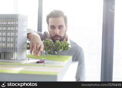 Serious architect analyzing 3D project at desk in office