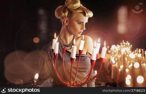 Serious blonde sexy woman keping candlestick