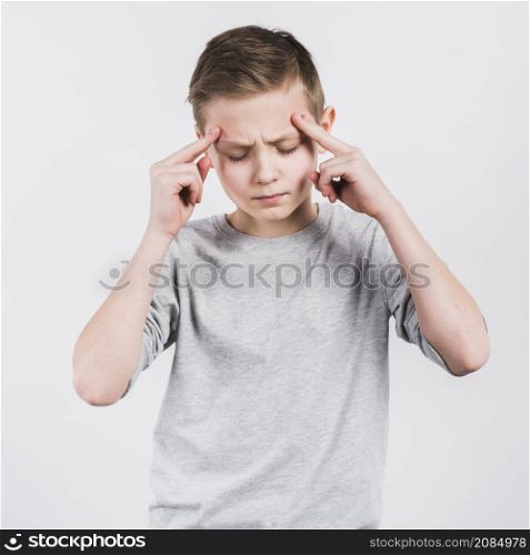 serious boy having headache standing against white background