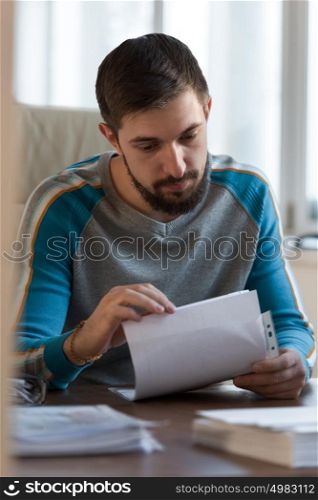 Serious businessman sitting in office and working with papers