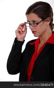 Serious businesswoman lifting glasses