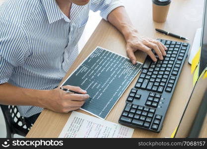 Serious busy hipster young web software developer programmer is coding or programming on a desktop computer information in modern office technologies Website design.