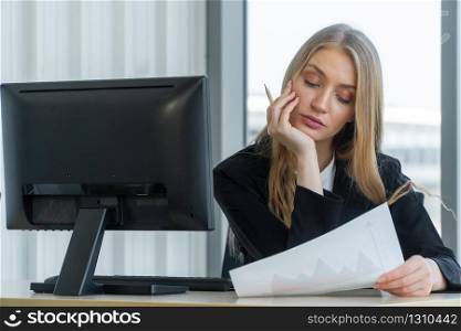 Serious caucasian businesswoman working on a computer at office desk, She looks confident and charming. Concept of equality in careers, talented women
