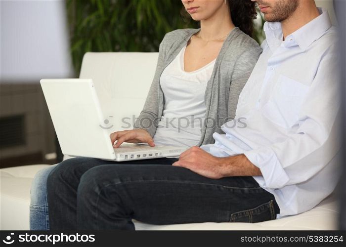 Serious couple using a laptop