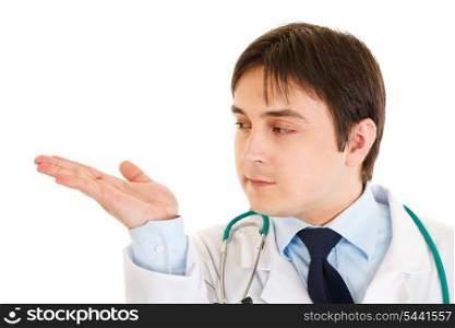 Serious doctor presenting something on empty hand isolated on white&#xA;