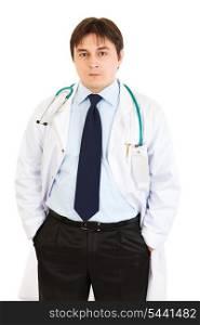 Serious doctor with stethoscope keeping his hands in pockets isolated on white&#xA;