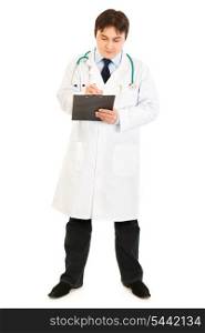 Serious doctor with stethoscope making notes in medical chart isolated on white&#xA;