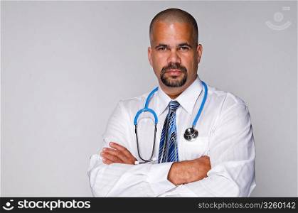 Serious Doctor with stethoscope with arms folded.