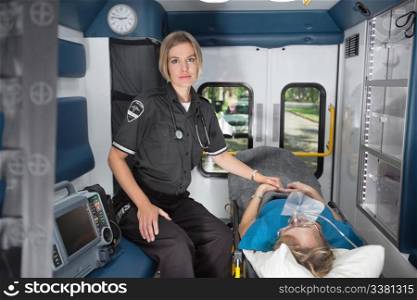 Serious emergency medical professional in ambulance with senior female patient