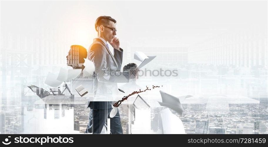 serious engrossed businessman with glasses making a phone call and looking at documents standing in office with two other businessmen citting aside with a cityscape background. serious businessman with glasses, making a phone call and looking at documents