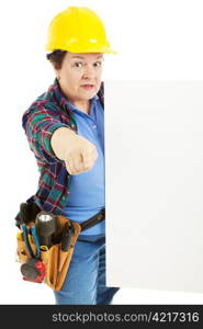 Serious female construction worker pointing to you and holding a sign.