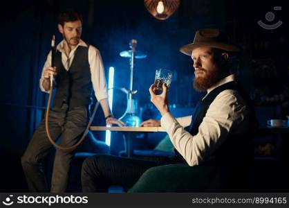 Serious guys smoking hookah while rest in pub. Male bachelor mafia party in restaurant concept. Serious guys smoking hookah while rest in pub