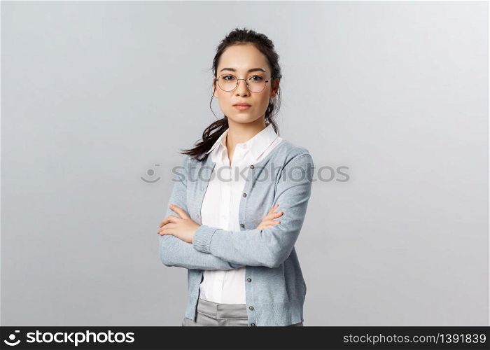 Serious-looking determined attractive asian woman, tutor or teacher starting online lesson with class standing self-assured with normal focused expression, cross arms on chest.. Serious-looking determined attractive asian woman, tutor or teacher starting online lesson with class standing self-assured with normal focused expression, cross arms on chest