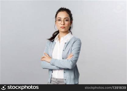 Serious-looking determined attractive asian woman, tutor or teacher starting online lesson with class standing self-assured with normal focused expression, cross arms on chest.. Serious-looking determined attractive asian woman, tutor or teacher starting online lesson with class standing self-assured with normal focused expression, cross arms on chest