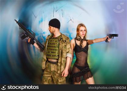 serious man and attractive women in military style with weapon