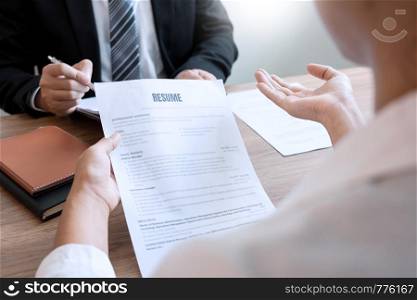 Serious man has a business meeting reading a resume about hiring decision during a job interview in company, attractive and professionally dressed, employment recruitment concept