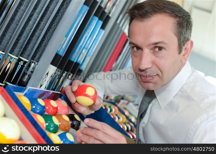 serious man prepares balls for start of game billiard