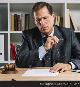 serious mature lawyer reading document desk courtroom