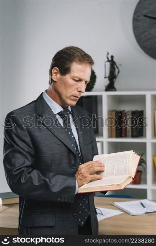 serious mature lawyer reading law book courtroom