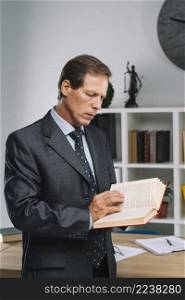 serious mature lawyer reading law book courtroom