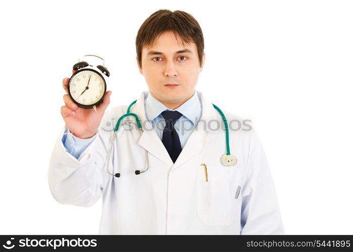Serious medical doctor holding alarm clock in hand isolated on white&#xA;
