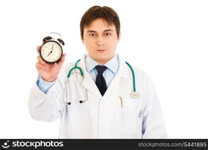 Serious medical doctor holding alarm clock in hand isolated on white&#xA;