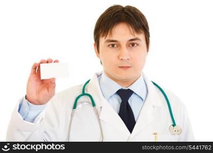 Serious medical doctor holding blank business card in hand isolated on white&#xA;