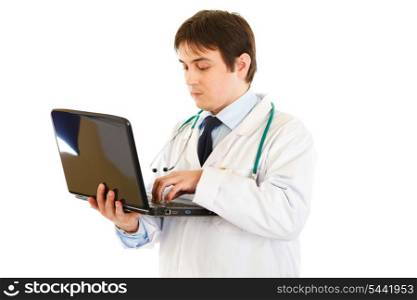 Serious medical doctor working on laptop isolated on white&#xA;