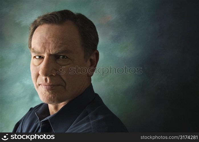 Serious middle-aged Caucasian man on studio background.