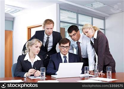 Serious people in business suits looking at laptop monitor