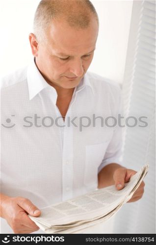 Serious senior businessman professional portrait read newspapers white shirt