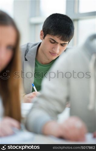 Serious students sitting for an examination in a classroom.