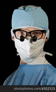 serious surgeon in scrubs and magnifying microsurgery glasses