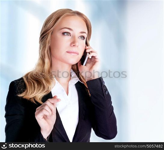 Serious woman talking on mobile phone near office building, professional conversation, smart business people concept