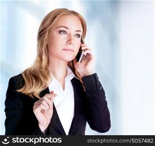 Serious woman talking on mobile phone near office building, professional conversation, smart business people concept
