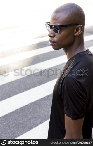 serious young male athlete black shirt wearing sunglasses looking away