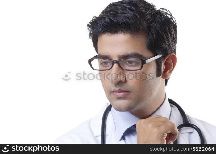Serious young male doctor over white background
