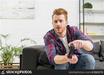 serious young man playing video game home
