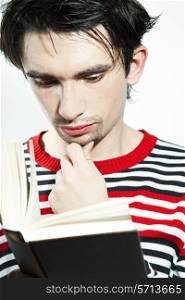 serious young man reading a book on a white background