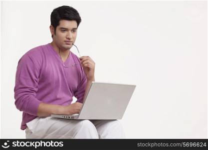 Serious young man using laptop