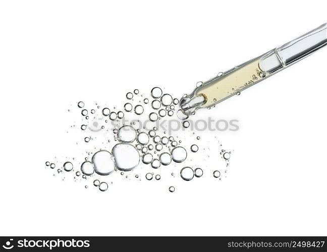 Serum oil in pipette isolated on white background. Cosmetic liquid dropper pipet with bubbles top view.