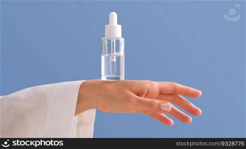 Serum with a pipette in female hands on a bright blue background.. Serum with a pipette in female hands on a blue background.