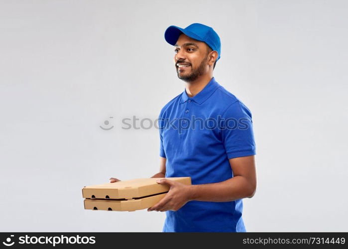 service and people concept - happy indian delivery man with pizza boxes in blue uniform over grey background. happy indian delivery man with pizza boxes in blue