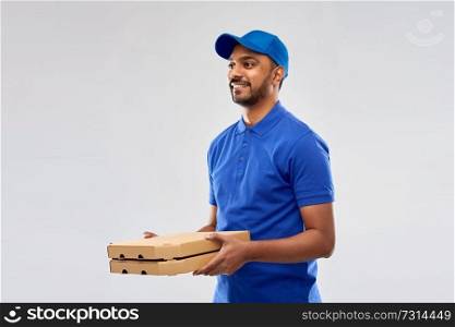 service and people concept - happy indian delivery man with pizza boxes in blue uniform over grey background. happy indian delivery man with pizza boxes in blue