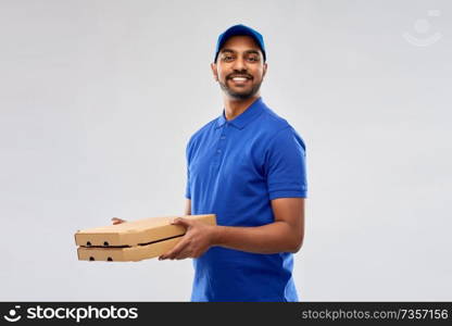 service and people concept - happy indian delivery man with pizza boxes in blue uniform over grey background. happy indian delivery man with pizza boxes in blue