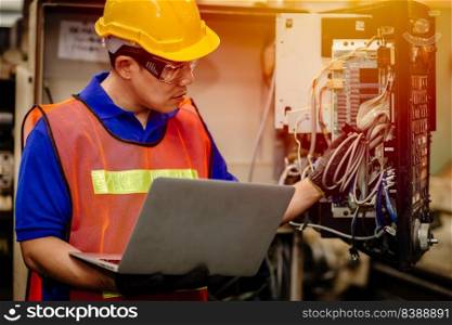 Service engineer team working with electronic wire back panel of heavy industry machine for maintenance repair and fix with laptop computer for analysis problems.