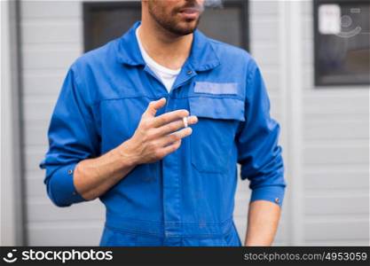 service, repair, maintenance and people concept - close up of auto mechanic smoking cigarette. close up of auto mechanic smoking cigarette