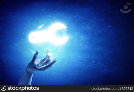 Service symbol. Person hand taking glowing tool sign on blue background